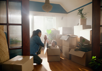 Happy family, son and mother or high five in new home with boxes, celebration and property investment. Real estate, woman and child with moving day, fresh start or success with bond payment on house stock photo