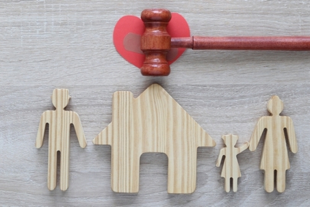 Divorce lawyer Or Attorney, Husband and wife splitting children on wooden background,Joint child custody and alimony concept.