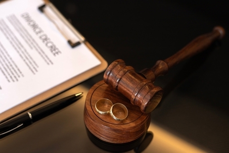 Divorce decree, gavel and wedding rings