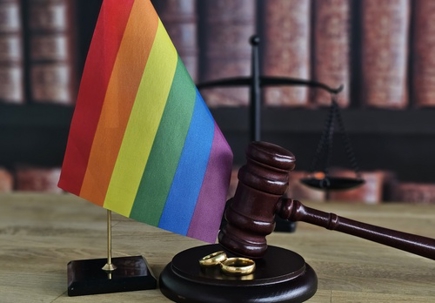 LGBT equality and laws concept. Wooden judge gavel with LGBT flag.