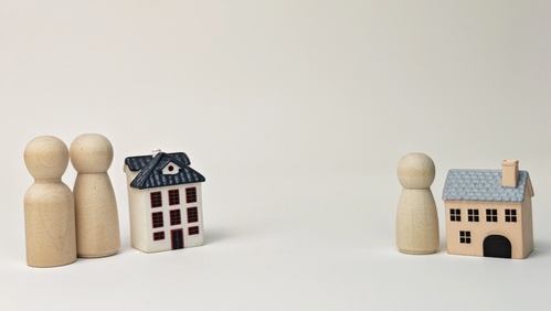 Family Separation and Child Custody Concept with Wooden Figures and Miniature Houses Symbolizing Divorce, Shared Parenting and Property Division.